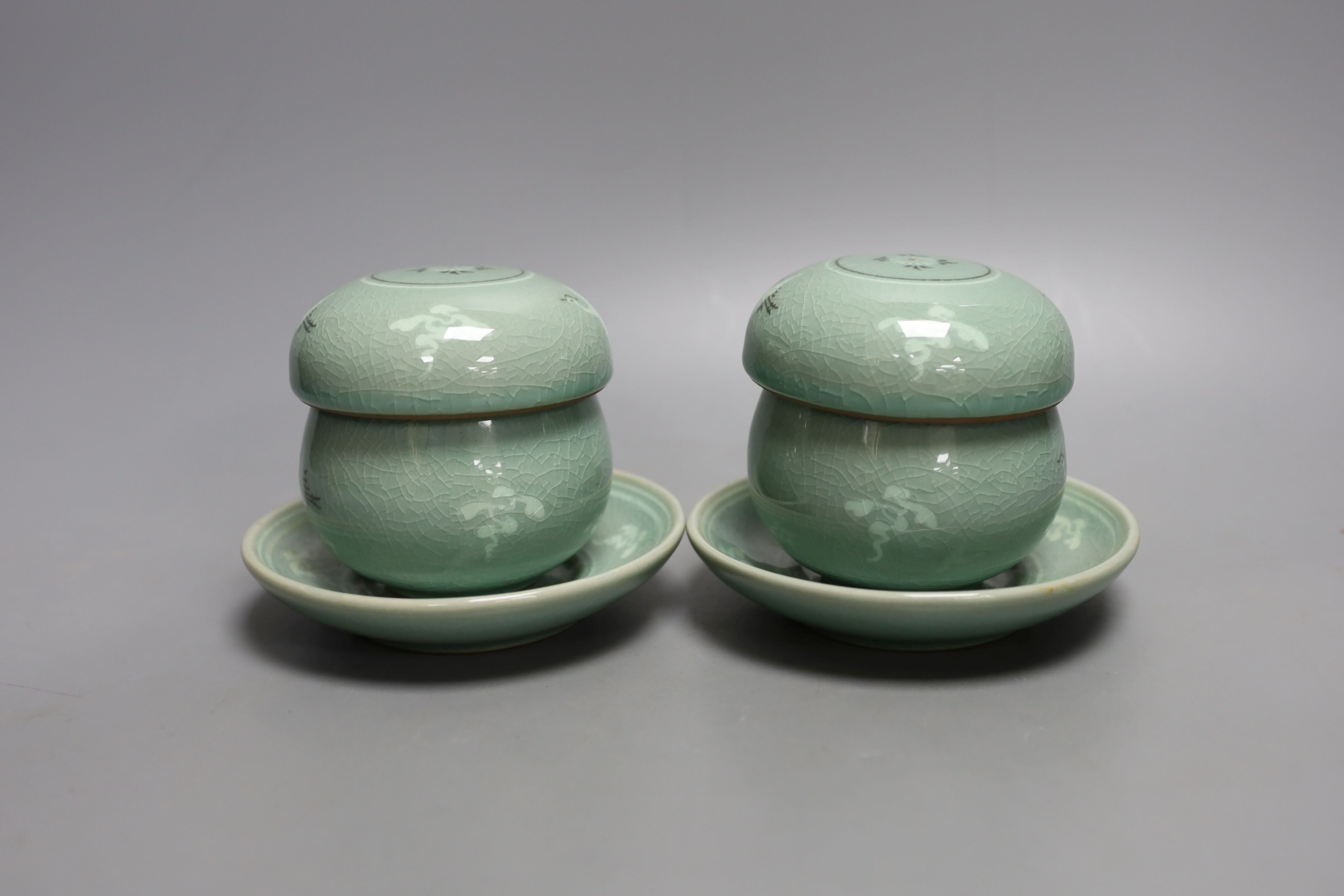 A pair of Korean green glazed pottery tea bowls, cover and stand with strainer each inside - 11cm tall